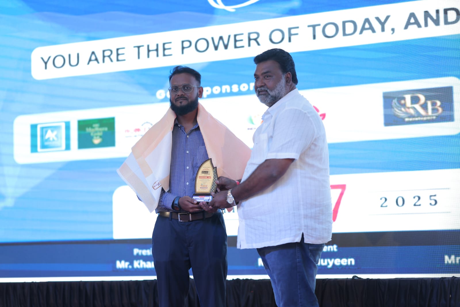 Hunain Bagaban receiving recognition at an event